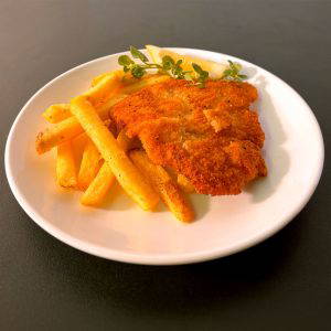 Kids-Breaded-Chicken-IMG_9871-WEB02 - Mamuśka! Restaurant and Bar - Southbank Waterloo Crispy fried chicken cutlet with a side of thick-cut fries on a white plate, garnished with lemon and herbs.